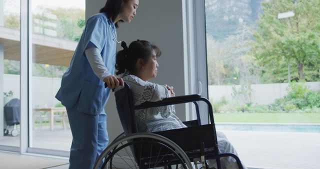 Asian female doctor pushing female patient in wheelchair at hospital. medicine, health and healthcare services.