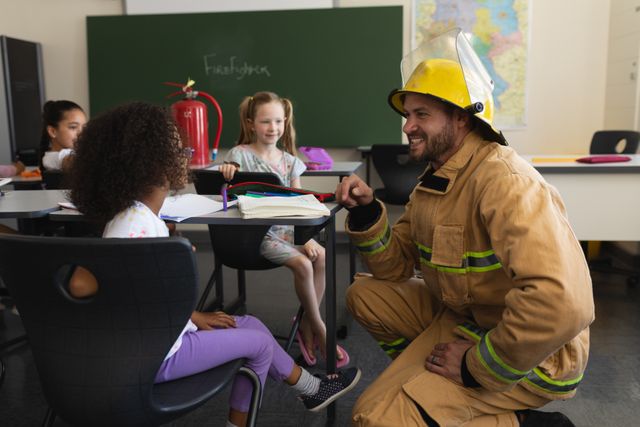 Side view of male firefighter teaching schoolkids about fire safety in classroom - Download Free Stock Photos Pikwizard.com