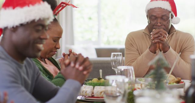 African american family praying before christmas dinner - Download Free Stock Photos Pikwizard.com
