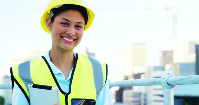 A young, smiling Latina construction worker in safety gear holds a clipboard, with copy space - Download Free Stock Photos Pikwizard.com