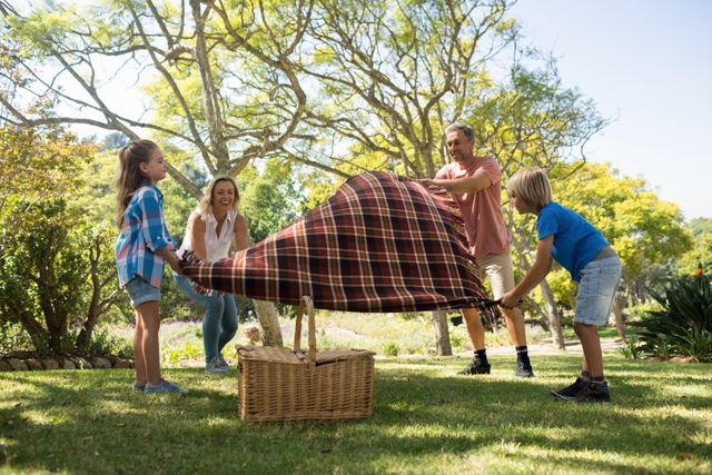 Family spreading the picnic blanket - Download Free Stock Photos Pikwizard.com