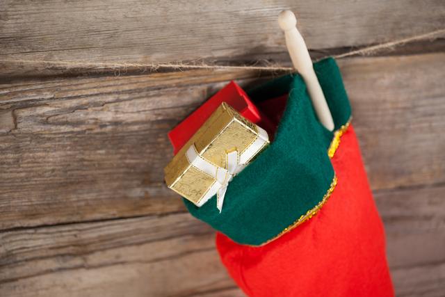 Christmas stocking with present box hanging against wooden wall - Download Free Stock Photos Pikwizard.com