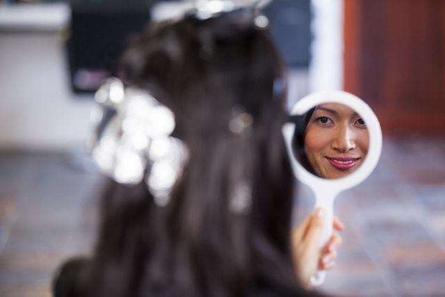 Woman looking at mirror while waiting with hair dye in her head - Download Free Stock Photos Pikwizard.com