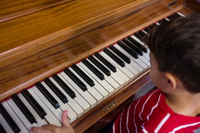 High angle view of boy playing piano in classroom - Download Free Stock Photos Pikwizard.com