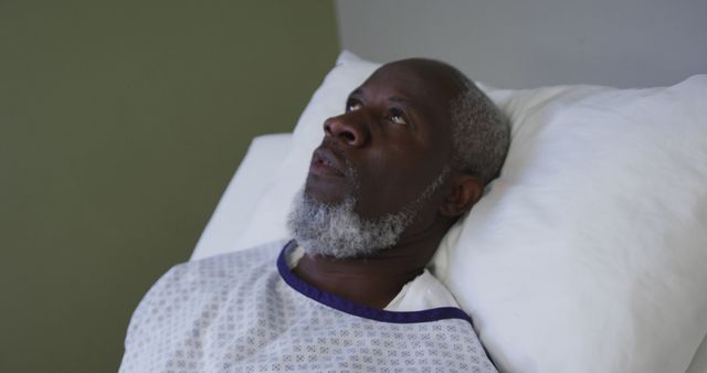 African american male patient lying in hospital bed and yawning. medicine, health and healthcare services.