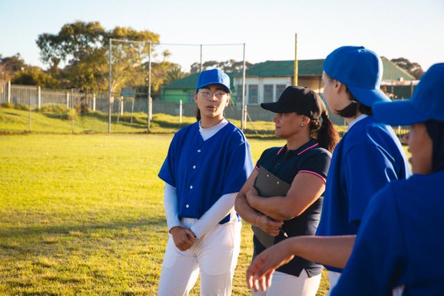 Diverse group of female baseball players with coach, discussing game tactics - Download Free Stock Photos Pikwizard.com