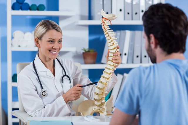 Physiotherapist explaining the spine model to patient - Download Free Stock Photos Pikwizard.com