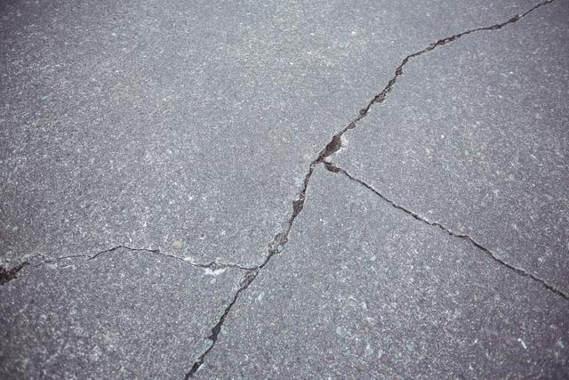 Close-up of cracked asphalt road background - Download Free Stock Photos Pikwizard.com