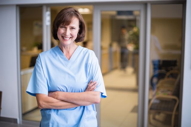 Portrait of smiling nurse standing with arms crossed - Download Free Stock Photos Pikwizard.com