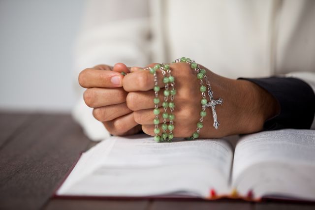 Praying hands of woman with a rosary on bible - Download Free Stock Photos Pikwizard.com