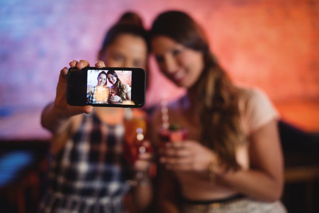 Young women taking a selfie while having cocktail drinks - Download Free Stock Photos Pikwizard.com