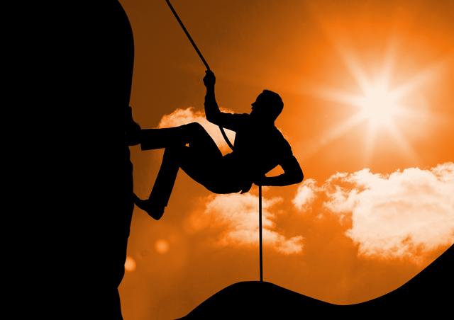 Silhouette of man climbing a mountain against sunny background - Download Free Stock Photos Pikwizard.com