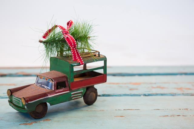 Toy tempo carrying christmas fir on wooden plank - Download Free Stock Photos Pikwizard.com