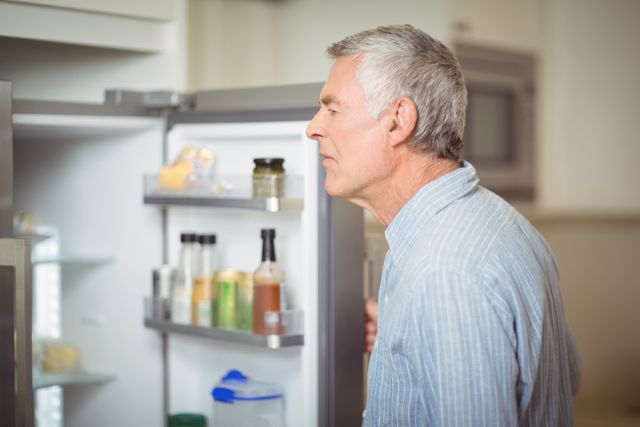Senior man looking in refrigerator - Download Free Stock Photos Pikwizard.com