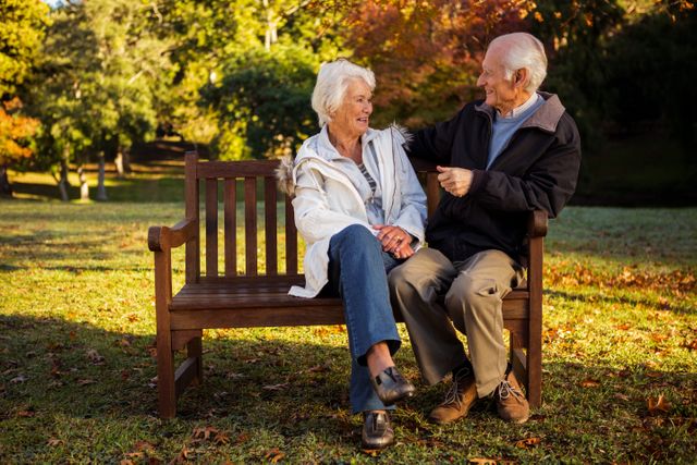  Elderly couple sitting on bench smiling at each other in park - Download Free Stock Photos Pikwizard.com