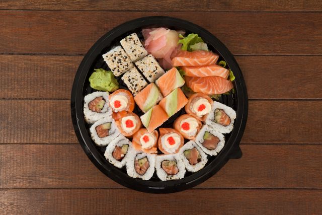 Set of assorted sushi kept in a black round box - Download Free Stock Photos Pikwizard.com