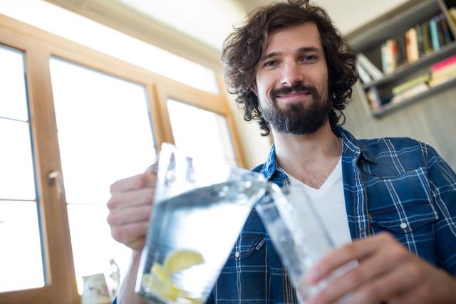 Smiling man pouring lemonade in the glass - Download Free Stock Photos Pikwizard.com