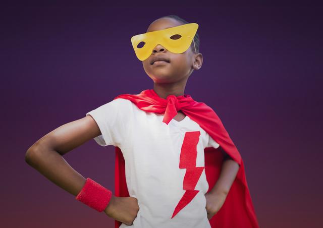 Girl in superhero costume standing with hands on hip against purple background - Download Free Stock Photos Pikwizard.com