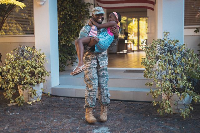 Happy african american soldier father holding daughter outside their house - Download Free Stock Photos Pikwizard.com