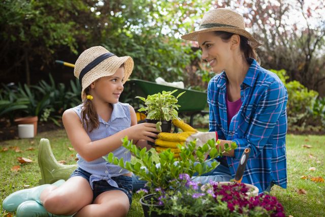 Smiling daughter and mother with potted plants - Download Free Stock Photos Pikwizard.com