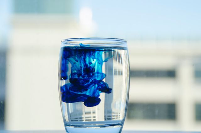 a glass of water with blue liquid in it - Download Free Stock Photos Pikwizard.com