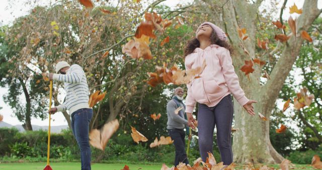 Image of happy african american daughter throwing leaves with father and grandfather in garden. Family, domestic life and togetherness concept digitally generated image.