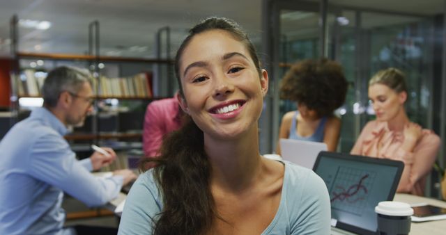 Portrait of caucasian businesswoman smiling over diverse business colleagues talking. working in business at a modern office.