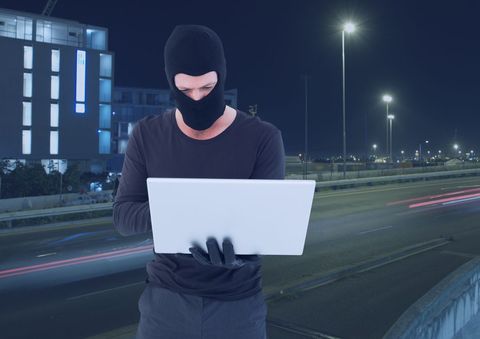 Criminal in balaclava with laptop in night city - Download Free Stock Photos Pikwizard.com