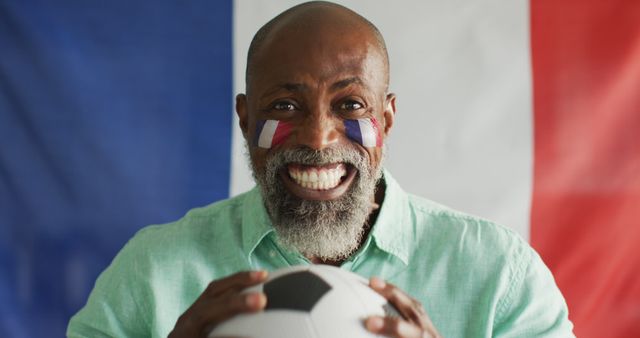 Image of happy african american man with flag of france holding soccer ball. Cheering, sport, soccer fan and patriotism concept.