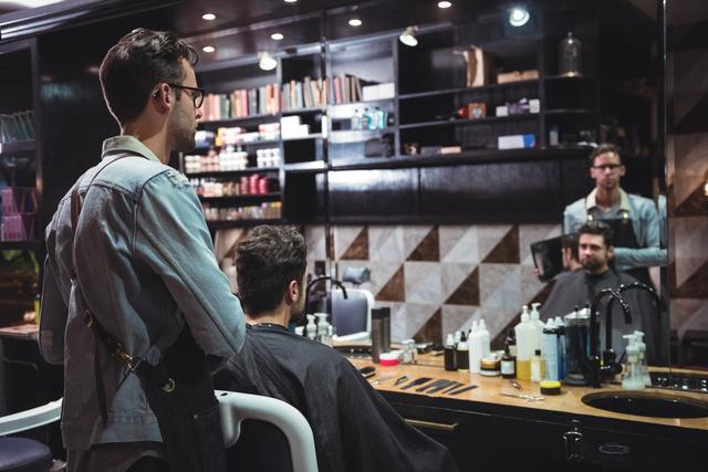 Barber showing man his haircut in mirror - Download Free Stock Photos Pikwizard.com