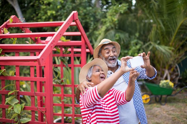 Cheerful couple taking selfie while standing in yard - Download Free Stock Photos Pikwizard.com