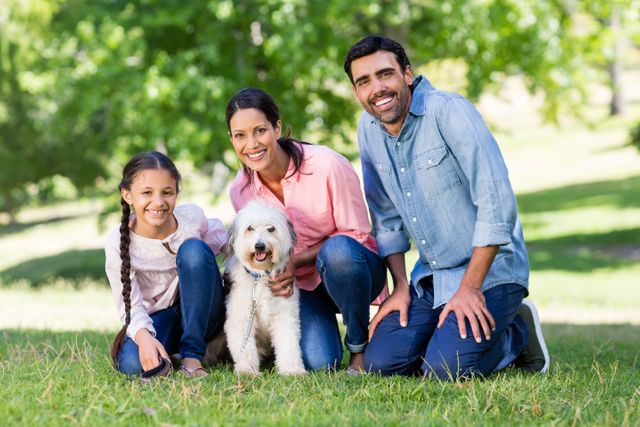 Happy family enjoying together with their pet dog in park - Download Free Stock Photos Pikwizard.com
