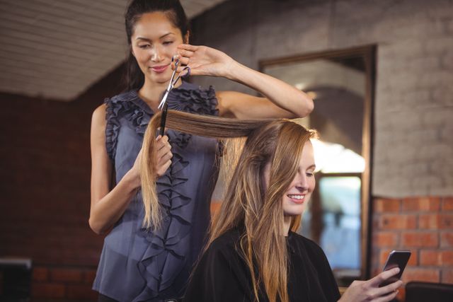 Smiling female getting her hair trimmed at a salon