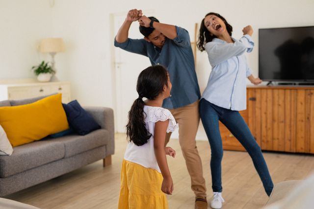 Happy hispanic daughter with parents dancing in living room - Download Free Stock Photos Pikwizard.com