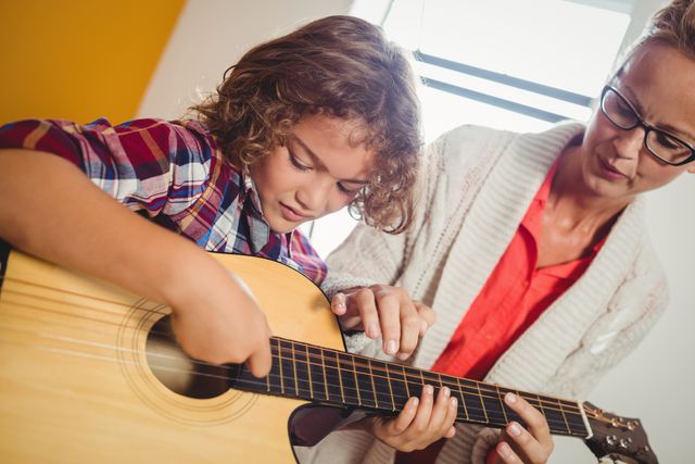 Boy learning how to play the guitar - Download Free Stock Photos Pikwizard.com