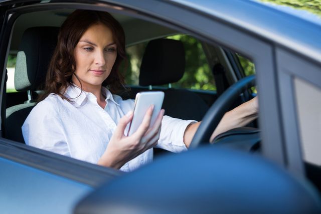 Woman using mobile phone while driving a car - Download Free Stock Photos Pikwizard.com