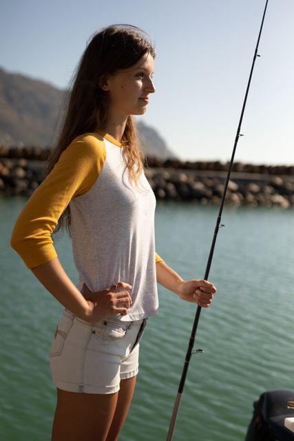 Young woman holding fishing rod near the sea - Download Free Stock Photos Pikwizard.com