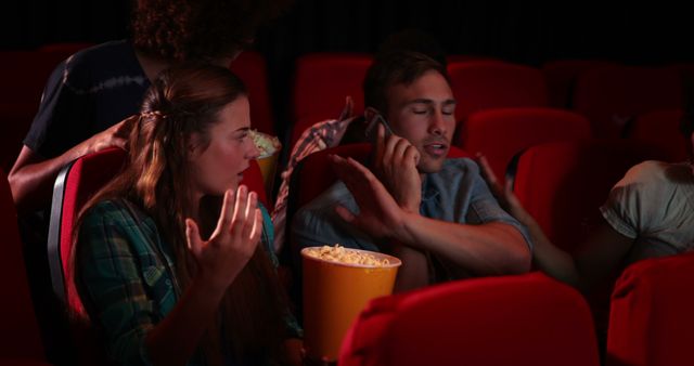 A group of young adults displays varied reactions while watching a movie and sharing popcorn. - Download Free Stock Photos Pikwizard.com