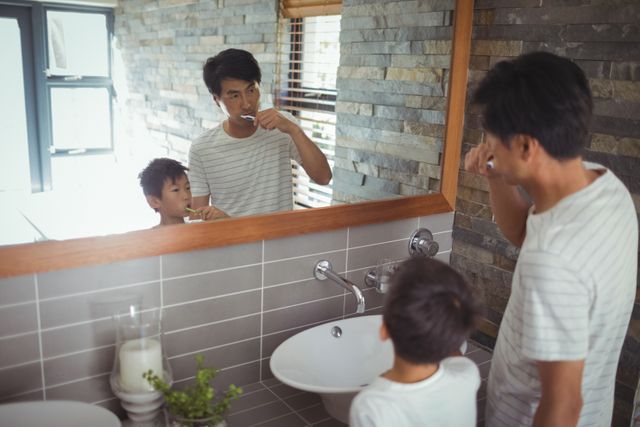 Father and son brushing teeth together in bathroom - Download Free Stock Photos Pikwizard.com