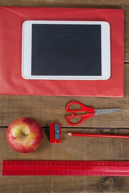 Apple, digital tablet and school supplies on wooden table - Download Free Stock Photos Pikwizard.com