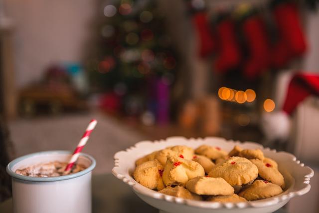Christmas cookies on plate with a cup of milk on wooden table during christmas time