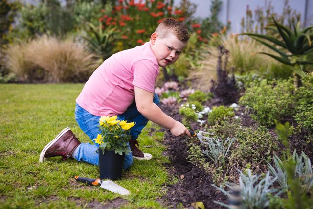 Caucasian boy holding a shovel gardening in the garden outdoors - Download Free Stock Photos Pikwizard.com