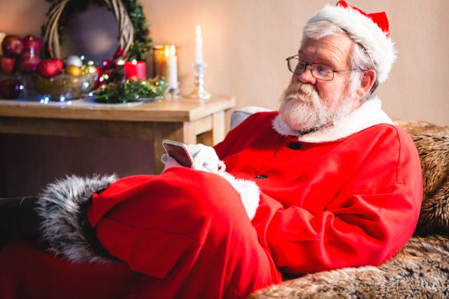 Santa claus sitting and using mobile phone - Download Free Stock Photos Pikwizard.com