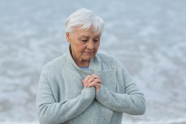 Senior woman doing meditation on the beach