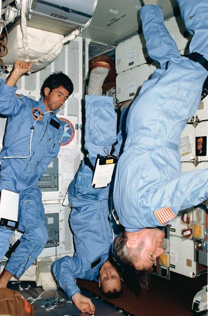 STS005-04-124 (14 Nov. 1982) --- Three members of the four-man STS-5 crew demonstrate the zero-gravity environment aboard the Earth-orbiting space shuttle Columbia. Astronaut Vance D. Brand, mission commander, holds a fairly typical Earth-bound pose, but crewmates, astronauts Robert F. Overmyer (center), pilot, and Dr. William B. Lenoir, mission specialist, perform body movements that could only be accomplished in zero-gravity. Dr. Joseph P. Allen IV, the flight’s other mission specialist, exposed this frame with a 35mm handheld camera. The four astronauts were in the middeck area of their reusable spacecraft when this photograph was made. Photo credit: NASA