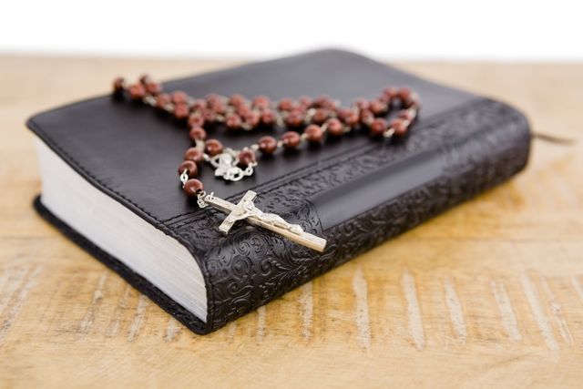 Close-up of bible and rosary beads on table