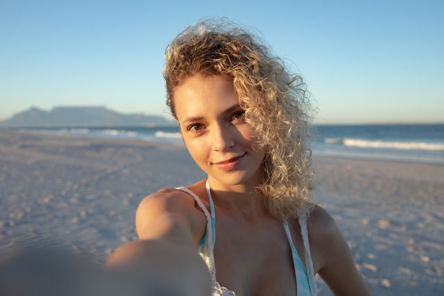 Beautiful woman standing on the beach- Download Free Stock Photos Pikwizard.com