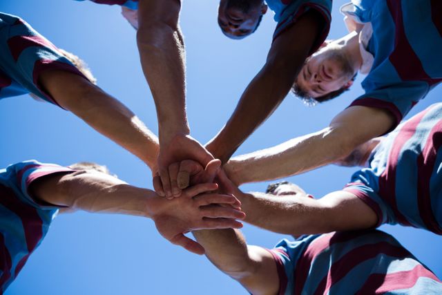 Low angle view of rugby team holding hands - Download Free Stock Photos Pikwizard.com