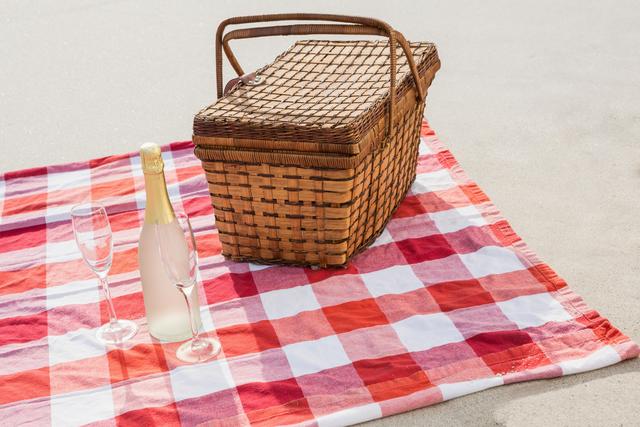 Two glasses, champagne bottle and picnic basket on beach blanket - Download Free Stock Photos Pikwizard.com
