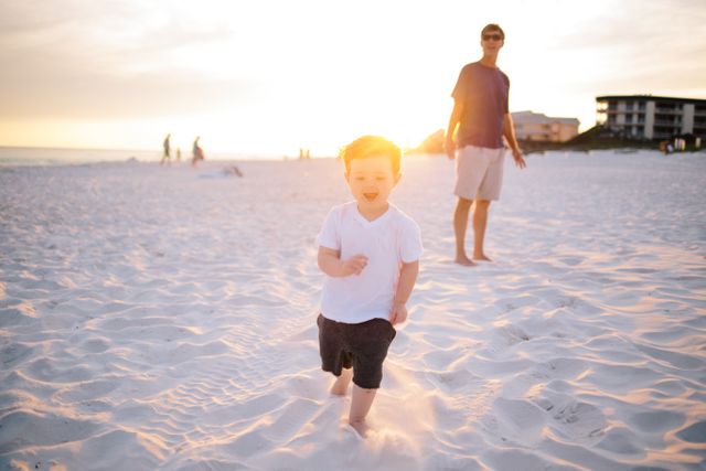 Child in White Shirt Running on White Sand during Dawn Near Man in Black Shirt - Download Free Stock Photos Pikwizard.com